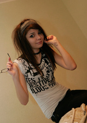 18 year old female Doris G slips off her underwear to pose naked on her bed